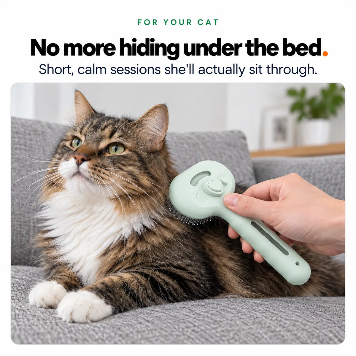 A long-haired tabby cat sitting calmly while being brushed with the green Mist Comb